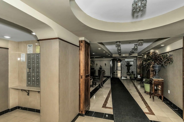 hall with tile patterned floors, a tray ceiling, recessed lighting, and mail area