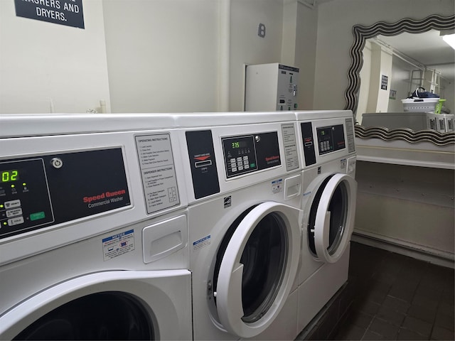 common laundry area with independent washer and dryer, stacked washer and clothes dryer, and dark tile patterned floors
