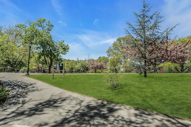 view of home's community with fence and a lawn