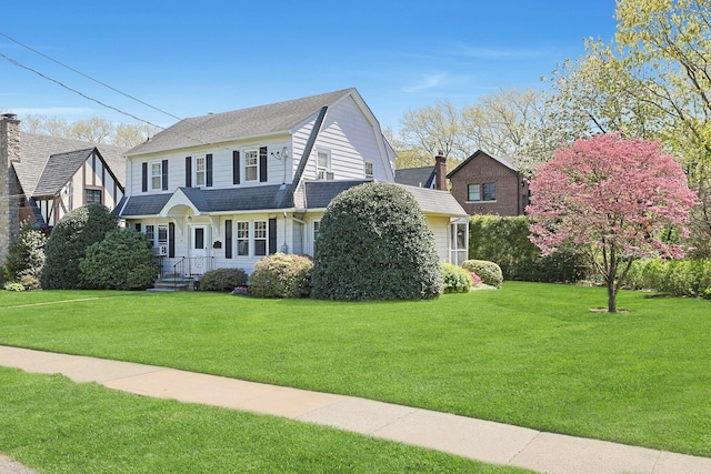 view of front of house featuring a gambrel roof and a front yard