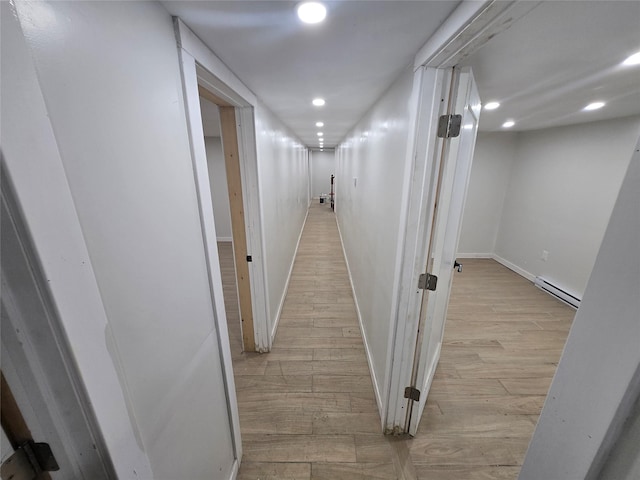 corridor featuring a baseboard radiator, light wood-type flooring, recessed lighting, and baseboards