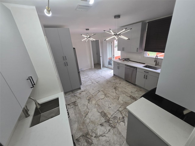 kitchen with gray cabinets, stainless steel dishwasher, light countertops, and a sink