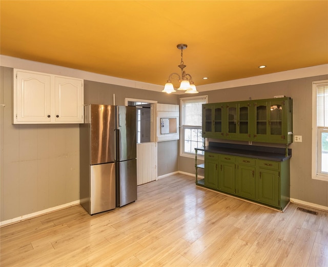 1603 Goshen Tpke, Middletown, NY 10941 - kitchen with green cabinetry, freestanding refrigerator, white cabinetry, a chandelier, and baseboards