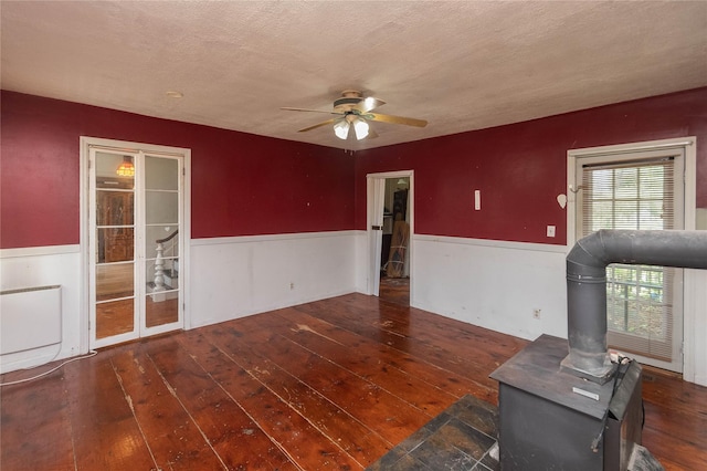 1603 Goshen Tpke, Middletown, NY 10941 - unfurnished living room with a wainscoted wall, hardwood / wood-style flooring, a ceiling fan, a wood stove, and a textured ceiling