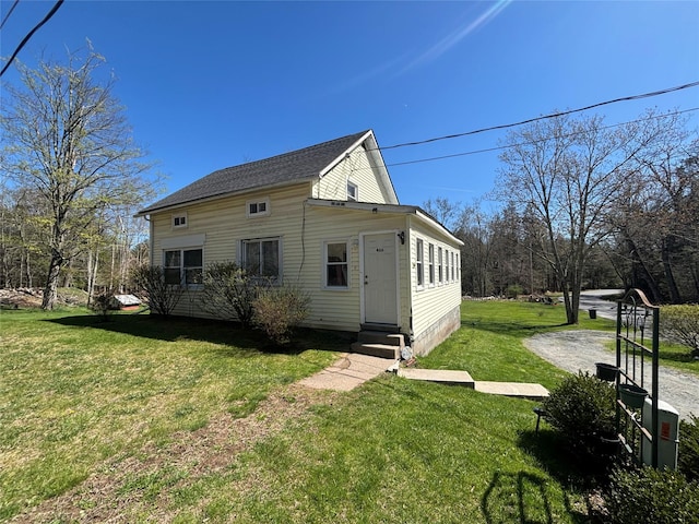 rear view of house with a lawn and entry steps