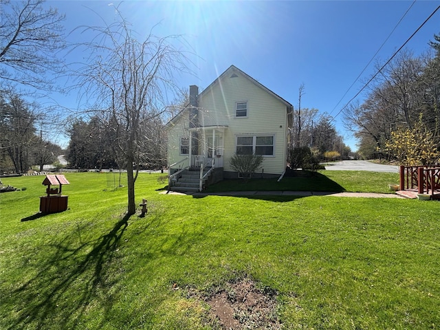 back of property with a lawn and a chimney