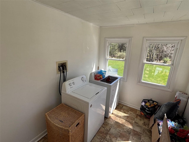 laundry room featuring stone finish floor, baseboards, separate washer and dryer, ornamental molding, and laundry area