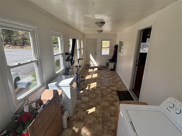 laundry room featuring stone finish floor, washer / clothes dryer, baseboards, ornamental molding, and laundry area