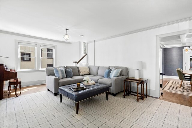 living area featuring crown molding, baseboards, and light wood-style floors