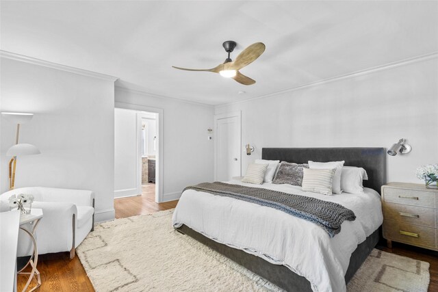 bedroom with crown molding, a ceiling fan, and wood finished floors