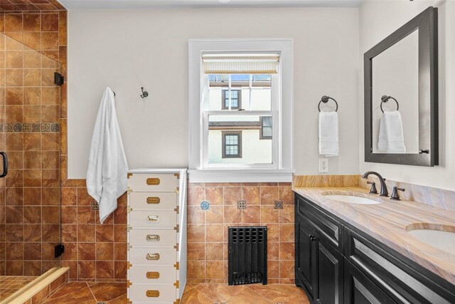 full bath featuring a sink, double vanity, radiator, tile walls, and a shower stall