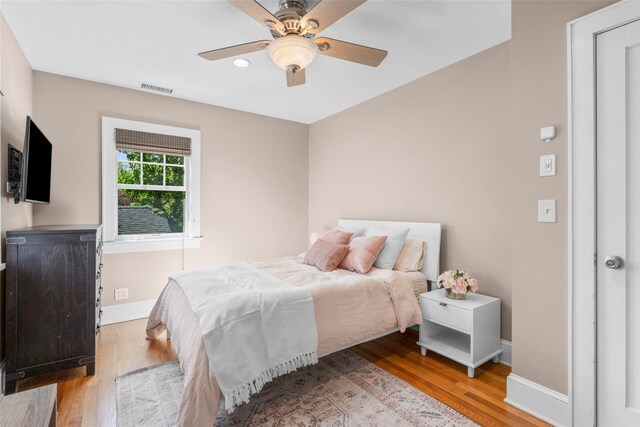 bedroom featuring a ceiling fan, visible vents, wood finished floors, baseboards, and recessed lighting