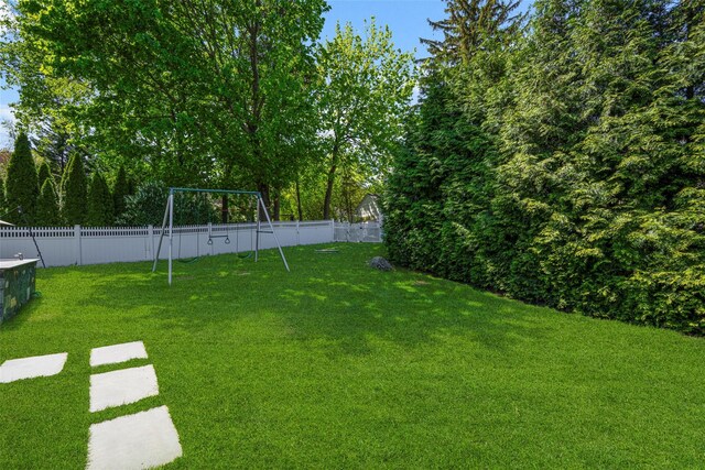 view of yard with a fenced backyard and a playground