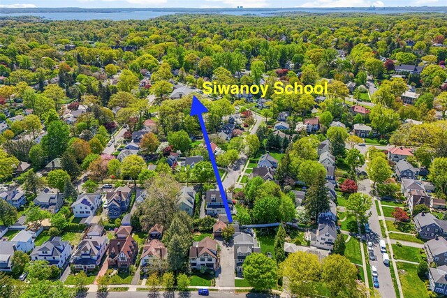 aerial view with a wooded view, a water view, and a residential view