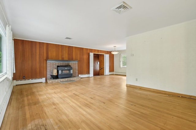 54 Cedar St, Stony Brook, NY 11790 - unfurnished living room with a baseboard radiator, light wood-style floors, a wood stove, baseboard heating, and crown molding