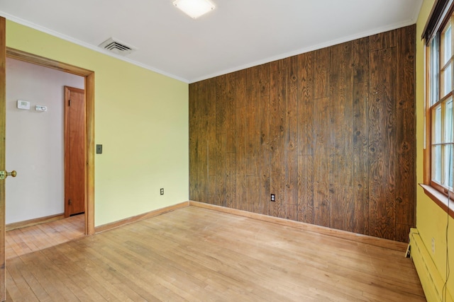 54 Cedar St, Stony Brook, NY 11790 - empty room with wood finished floors, baseboard heating, wood walls, baseboards, and crown molding