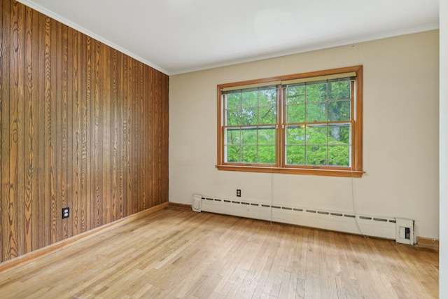 54 Cedar St, Stony Brook, NY 11790 - empty room with baseboard heating, wood-type flooring, baseboards, crown molding, and wooden walls