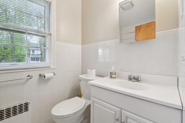 54 Cedar St, Stony Brook, NY 11790 - bathroom with radiator, tile walls, toilet, and vanity