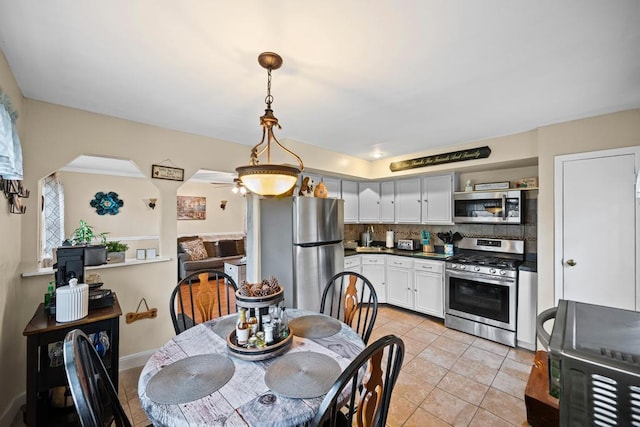 133 Parkwood Dr, Shirley, NY 11967 - dining space featuring light tile patterned floors, a ceiling fan, and arched walkways