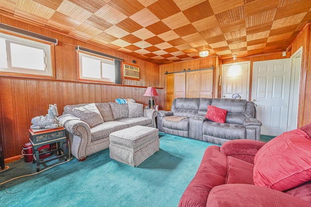 carpeted living area featuring wooden walls, crown molding, wooden ceiling, and a barn door