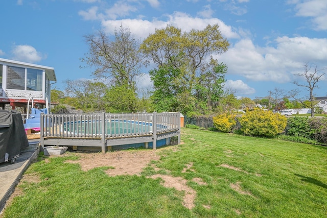 view of yard featuring a deck and a fenced in pool