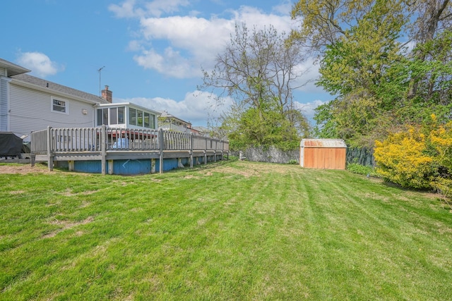 view of yard featuring an outdoor structure, a wooden deck, and a storage shed