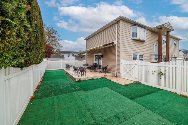 68 Lincoln Ave, Island Park, NY 11558 - rear view of house featuring a lawn, a gate, a patio, and a fenced backyard