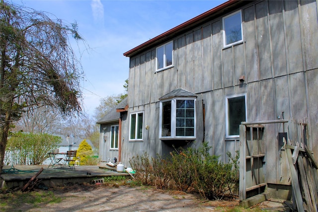 rear view of property featuring a deck and board and batten siding