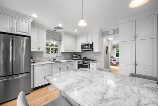 97 Highview Ave, Tuckahoe, NY 10707 - kitchen with appliances with stainless steel finishes, a sink, white cabinets, light wood finished floors, and decorative backsplash