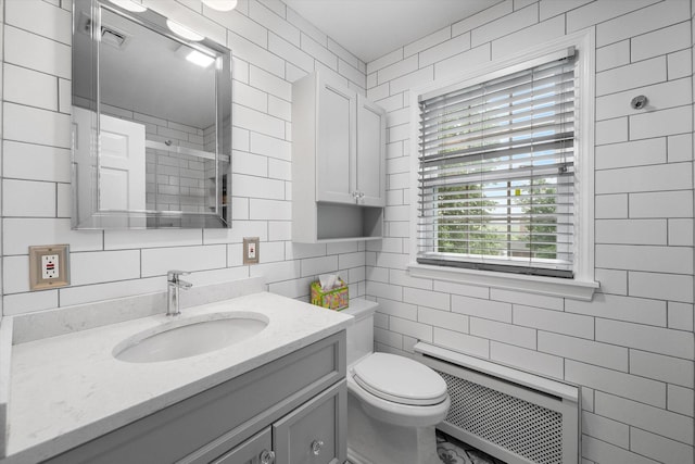 97 Highview Ave, Tuckahoe, NY 10707 - full bathroom with tile walls, radiator, vanity, toilet, and a shower