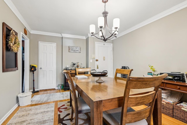 200 N Village Ave Unit D10, Rockville Centre, NY 11570 - dining room with crown molding, baseboards, a chandelier, and light wood-style floors