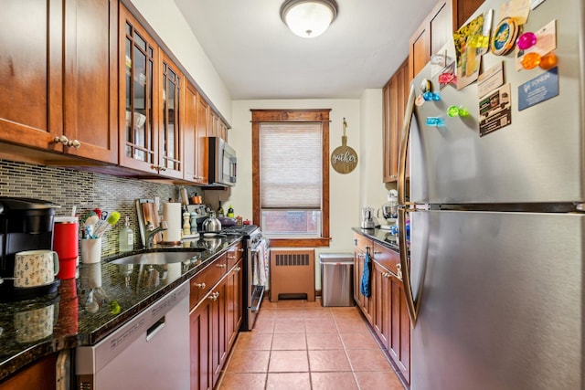 200 N Village Ave Unit D10, Rockville Centre, NY 11570 - kitchen featuring decorative backsplash, a sink, glass insert cabinets, dark stone counters, and stainless steel appliances