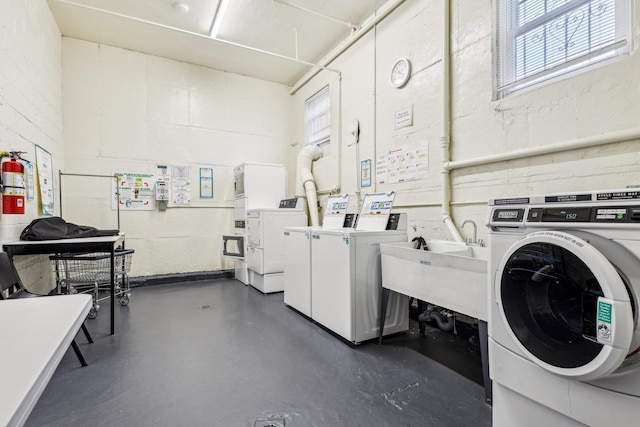 200 N Village Ave Unit D10, Rockville Centre, NY 11570 - community laundry room with washer and dryer, concrete block wall, and plenty of natural light