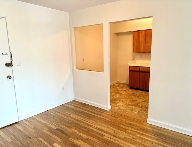 spare room with light wood-type flooring and baseboards