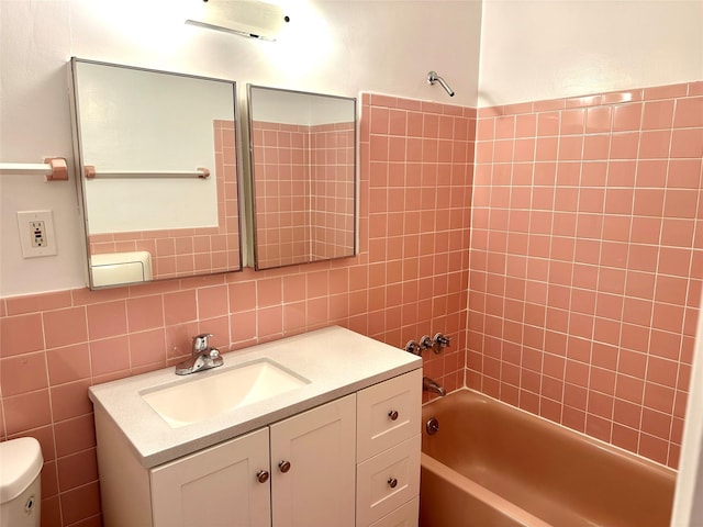 full bath featuring tile walls, vanity, toilet, and shower / tub combination