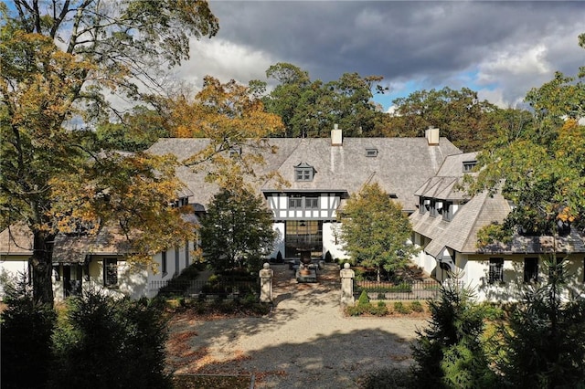 back of property featuring fence, a chimney, and a balcony