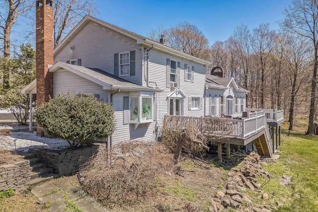 rear view of property with a wooden deck and a chimney