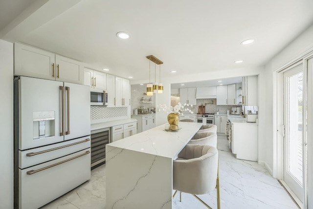 kitchen with high quality appliances, tasteful backsplash, marble finish floor, and wine cooler
