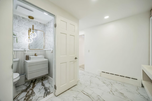 bathroom featuring baseboard heating, vanity, baseboards, toilet, and marble finish floor