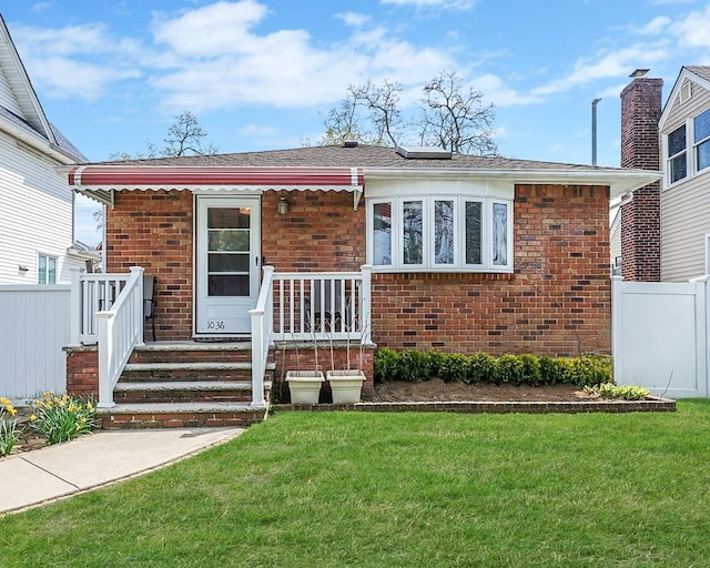 1036 Pacific St, Baldwin Harbor, NY 11510 - bungalow-style house featuring fence, a front lawn, and brick siding