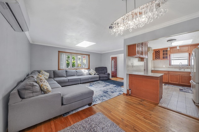 1036 Pacific St, Baldwin Harbor, NY 11510 - living area featuring crown molding, baseboards, light wood-type flooring, a wall mounted AC, and a skylight