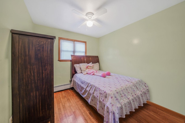 1036 Pacific St, Baldwin Harbor, NY 11510 - bedroom featuring ceiling fan, a baseboard heating unit, and hardwood / wood-style flooring