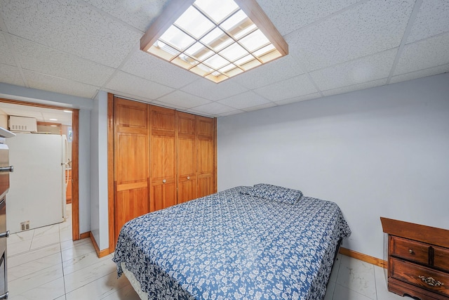 1036 Pacific St, Baldwin Harbor, NY 11510 - bedroom featuring freestanding refrigerator, baseboards, a paneled ceiling, and a closet