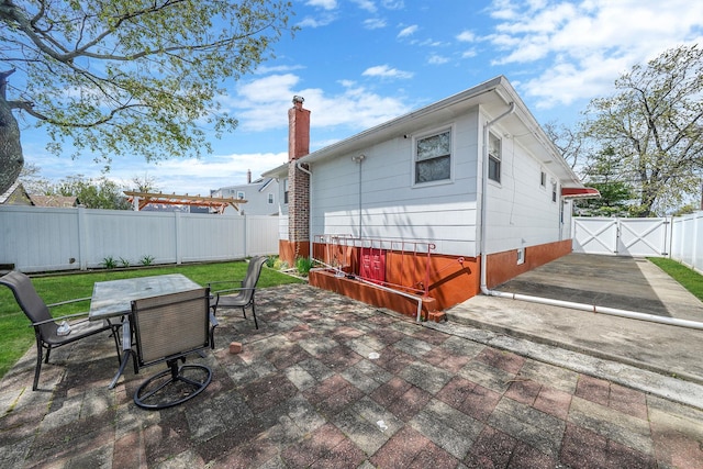 1036 Pacific St, Baldwin Harbor, NY 11510 - back of property featuring outdoor dining space, a fenced backyard, a gate, a chimney, and a patio