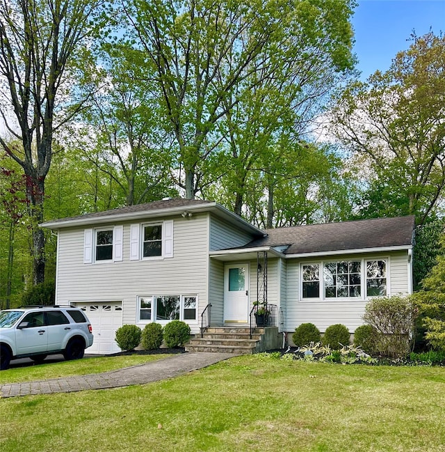split level home featuring an attached garage and a front lawn