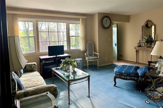 living area featuring baseboards, carpet flooring, and visible vents