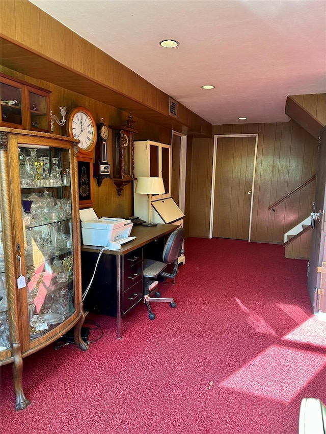 office featuring carpet floors, wood walls, and visible vents