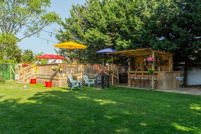 view of yard with outdoor dry bar and a deck