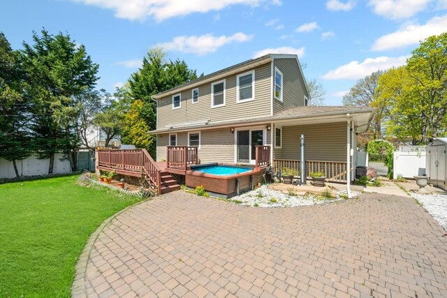 back of property with a patio, a lawn, a jacuzzi, a deck, and fence
