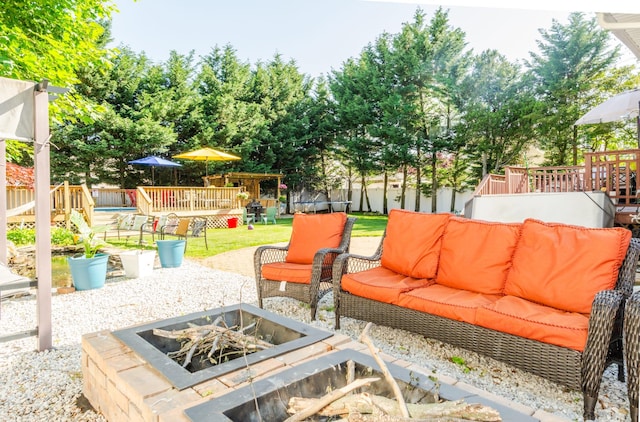 view of patio with an outdoor living space with a fire pit, a deck, and a trampoline